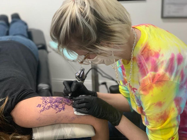 Woman getting a floral tattoo